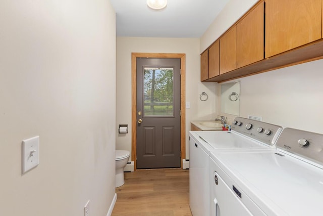 2294 Pinewood St, Jenison, MI 49428 - washroom with washing machine and clothes dryer, light wood-style flooring, a baseboard radiator, and baseboards