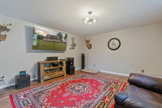 123 N F St, Trufant, MI 49347 - living room featuring wood finished floors, baseboards, and a chandelier
