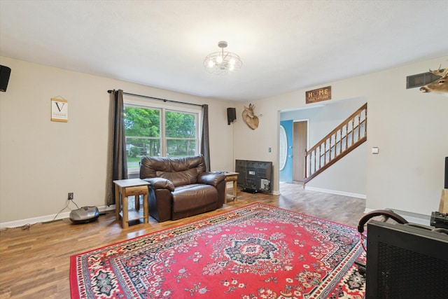 123 N F St, Trufant, MI 49347 - living room featuring stairway, wood finished floors, baseboards, and a chandelier