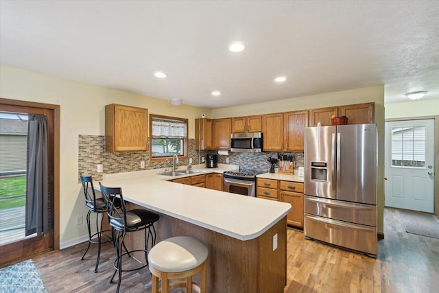 123 N F St, Trufant, MI 49347 - kitchen featuring appliances with stainless steel finishes, a sink, a peninsula, plenty of natural light, and recessed lighting