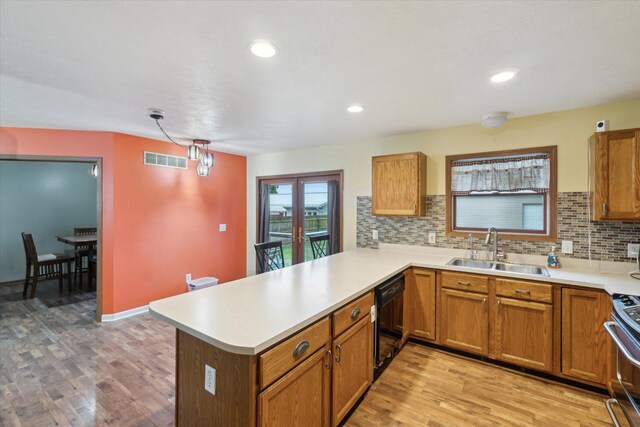 123 N F St, Trufant, MI 49347 - kitchen featuring a sink, dishwasher, a peninsula, light countertops, and light wood finished floors