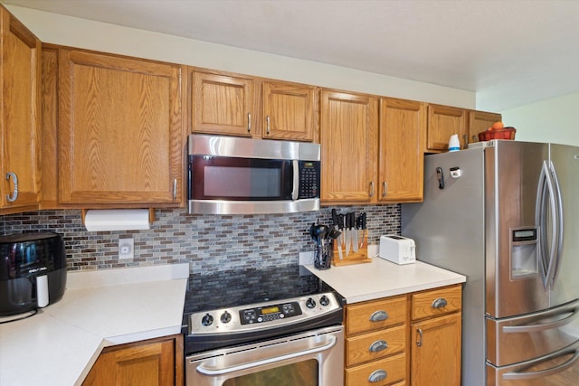 123 N F St, Trufant, MI 49347 - kitchen featuring stainless steel appliances, light countertops, backsplash, and brown cabinetry
