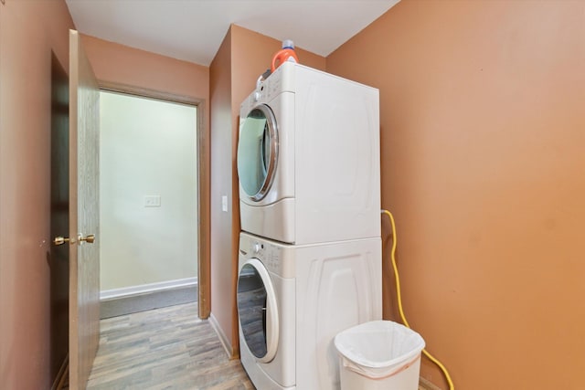123 N F St, Trufant, MI 49347 - laundry room featuring stacked washer and clothes dryer, light wood-style floors, and baseboards