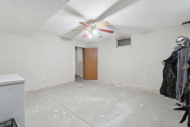 123 N F St, Trufant, MI 49347 - unfurnished living room featuring ceiling fan and concrete floors