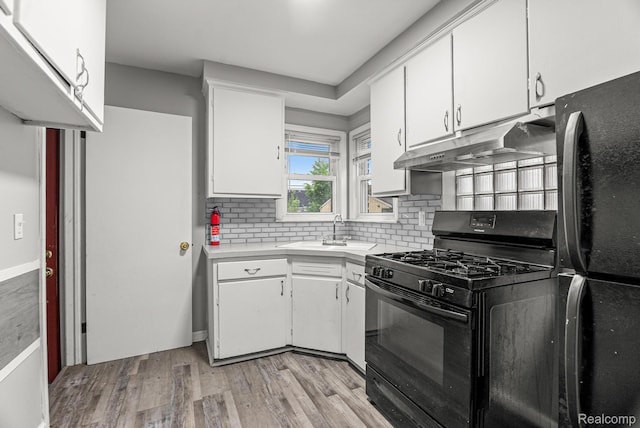 1860 Moran Ave, Lincoln Park, MI 48146 - kitchen featuring black appliances, a sink, under cabinet range hood, and white cabinets