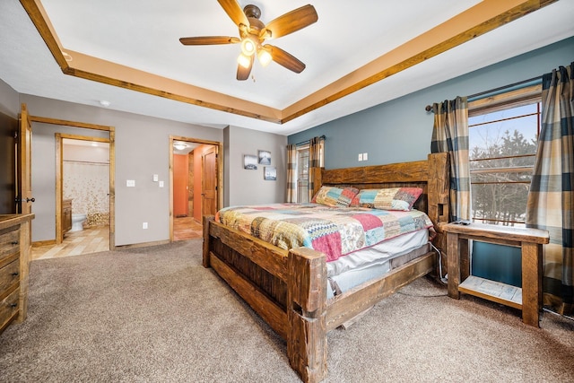 17582 Leroy Rd, Leroy, MI 49655 - carpeted bedroom with a tray ceiling, baseboards, ensuite bathroom, and ceiling fan