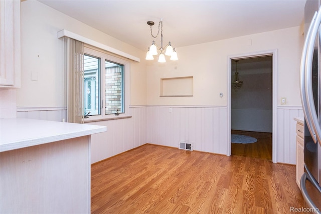 20550 Fairway Ln, Grosse Pointe Woods, MI 48236 - unfurnished dining area with wainscoting, a chandelier, and light wood-style flooring