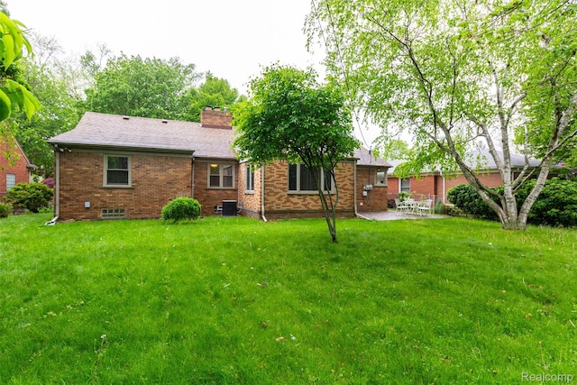 20550 Fairway Ln, Grosse Pointe Woods, MI 48236 - back of house featuring a patio area, a yard, brick siding, and a chimney