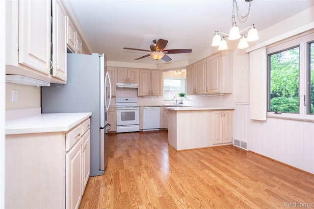 20550 Fairway Ln, Grosse Pointe Woods, MI 48236 - kitchen featuring white appliances, under cabinet range hood, light wood finished floors, and healthy amount of natural light