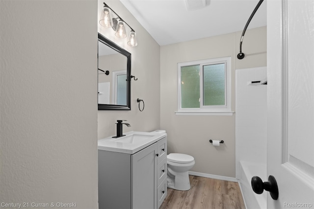 6262 Garden Ct, Warren, MI 48091 - full bath with vanity, toilet, wood finished floors, shower / washtub combination, and baseboards