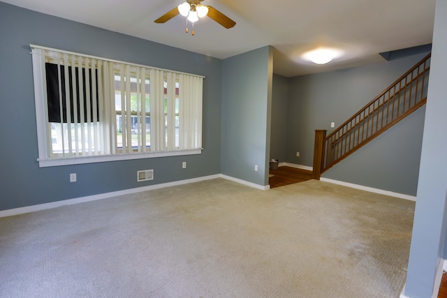 93 Illinois St, Battle Creek, MI 49014 - unfurnished room with carpet flooring, stairway, ceiling fan, and baseboards