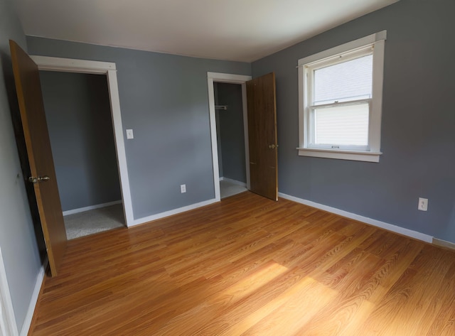 93 Illinois St, Battle Creek, MI 49014 - unfurnished bedroom featuring a closet, light wood-style flooring, and baseboards