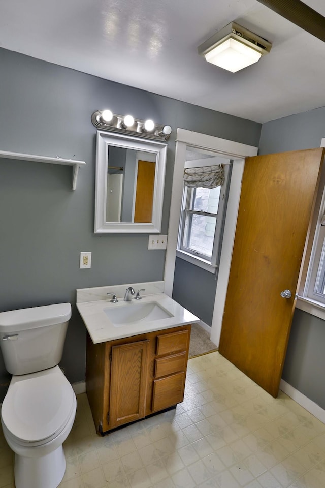 93 Illinois St, Battle Creek, MI 49014 - bathroom featuring vanity, toilet, baseboards, and tile patterned floors