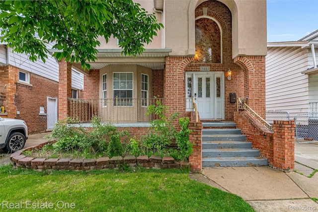 5410 Argyle St, Dearborn, MI 48126 - view of exterior entry featuring a porch, brick siding, and stucco siding