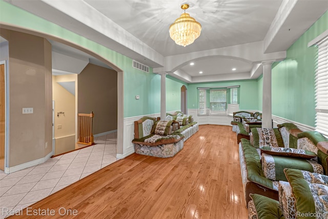 5410 Argyle St, Dearborn, MI 48126 - living room with arched walkways, decorative columns, wood finished floors, a raised ceiling, and wainscoting