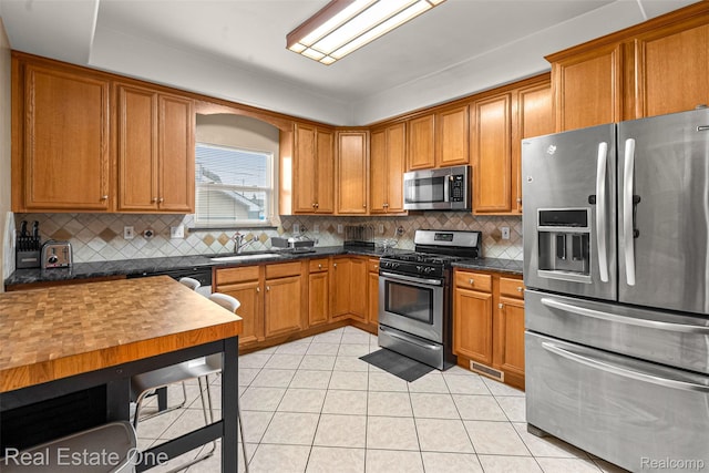 5410 Argyle St, Dearborn, MI 48126 - kitchen featuring stainless steel appliances, a sink, brown cabinetry, and backsplash
