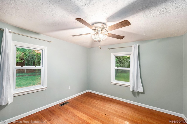 35825 Oakwood Ln, Westland, MI 48186 - unfurnished room with healthy amount of natural light, a textured ceiling, light wood-style floors, baseboards, and a ceiling fan