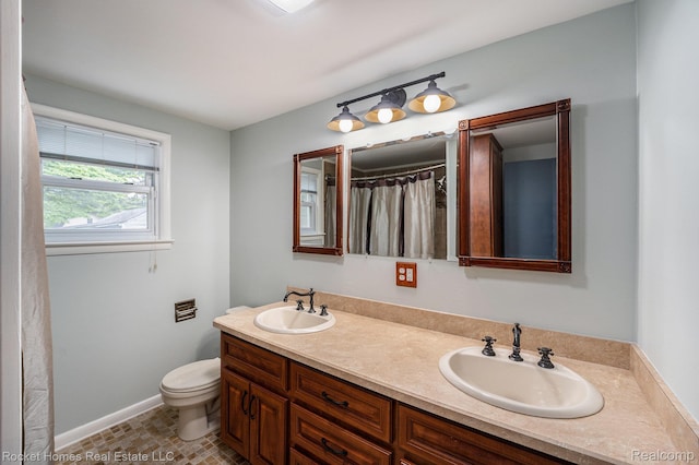 35825 Oakwood Ln, Westland, MI 48186 - full bathroom with double vanity, toilet, and baseboards