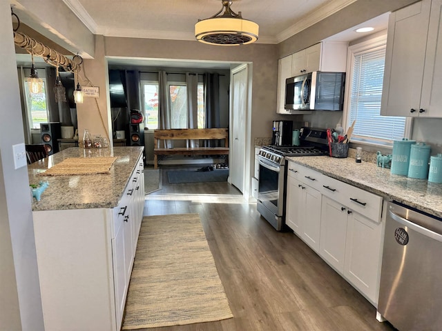 5547 Davison Rd, Davison, MI 48446 - kitchen featuring stainless steel appliances, ornamental molding, plenty of natural light, and white cabinetry