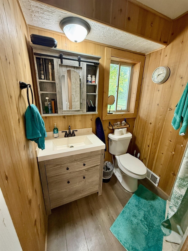 5547 Davison Rd, Davison, MI 48446 - bathroom with wooden walls, vanity, toilet, and wood finished floors