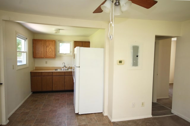 1772 E T Ave, Portage, MI 49002 - kitchen with freestanding refrigerator, brown cabinets, electric panel, ceiling fan, and light countertops