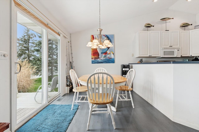 14814 Lark Dr, Camden, MI 49232 - dining room featuring vaulted ceiling, a chandelier, dark wood-style flooring, and baseboards