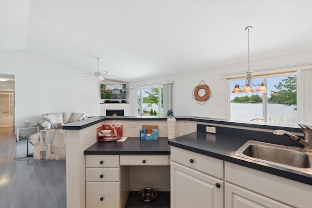 14814 Lark Dr, Camden, MI 49232 - kitchen with a sink, dark countertops, ceiling fan, a lit fireplace, and lofted ceiling
