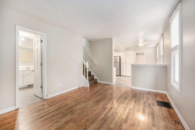1535 Colorado Ave SE, Grand Rapids, MI 49507 - unfurnished living room featuring wood-type flooring, stairway, and baseboards