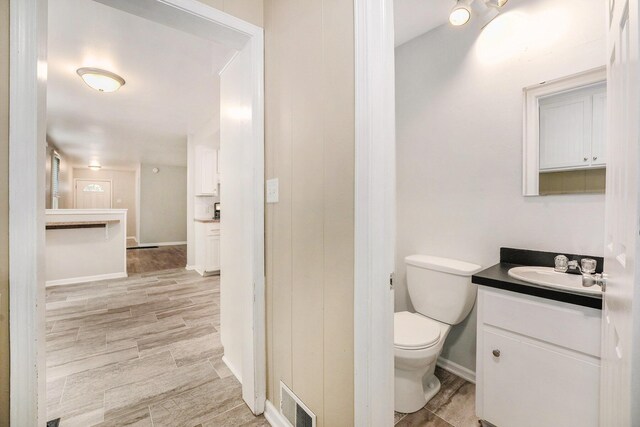 1535 Colorado Ave SE, Grand Rapids, MI 49507 - bathroom with vanity, toilet, baseboards, and wood finished floors