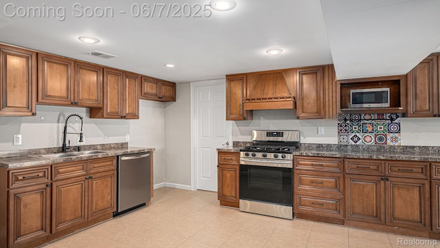 6288 Buckshore Dr, Whitmore Lake, MI 48189 - kitchen featuring stainless steel appliances, a sink, custom range hood, brown cabinets, and dark countertops