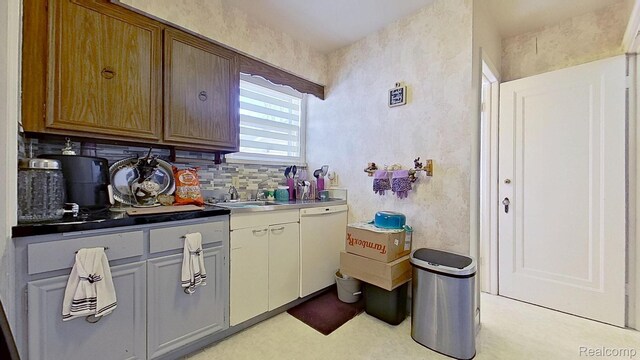 416 Marquette St, Flint, MI 48504 - kitchen with white dishwasher, a sink, decorative backsplash, and light floors