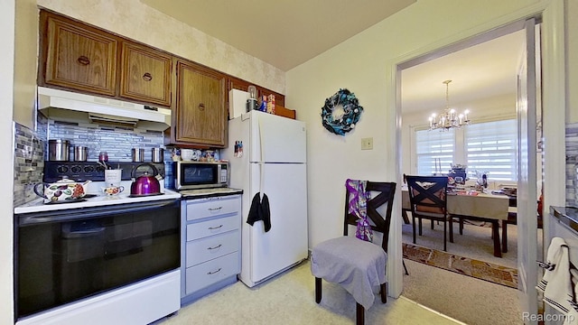 416 Marquette St, Flint, MI 48504 - kitchen featuring freestanding refrigerator, range with electric stovetop, under cabinet range hood, stainless steel microwave, and a chandelier