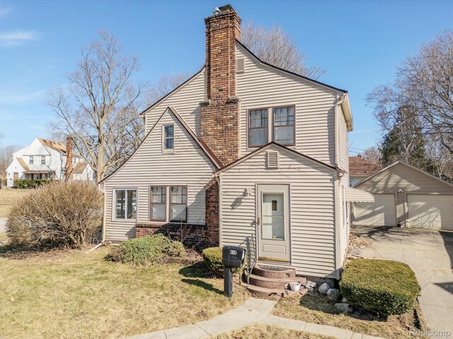 416 Marquette St, Flint, MI 48504 - view of front facade featuring an outbuilding, a chimney, a garage, and a front lawn