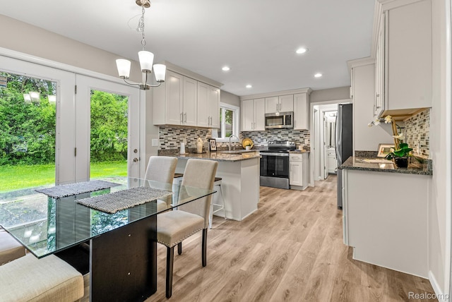 4766 Quarton Rd, Bloomfield, MI 48302 - kitchen with stainless steel appliances, decorative backsplash, dark stone countertops, light wood-style flooring, and recessed lighting