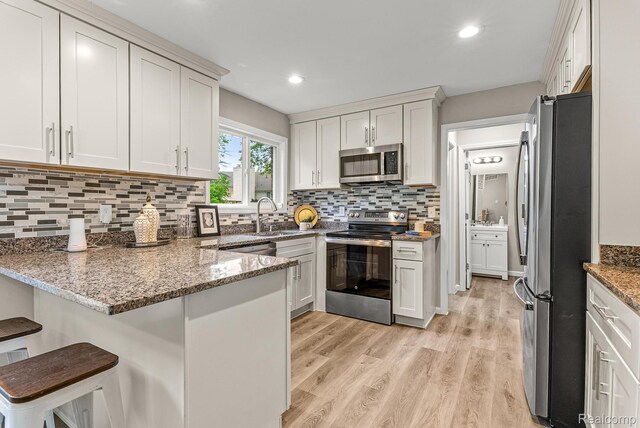 4766 Quarton Rd, Bloomfield, MI 48302 - kitchen with stainless steel appliances, a peninsula, stone countertops, decorative backsplash, and recessed lighting