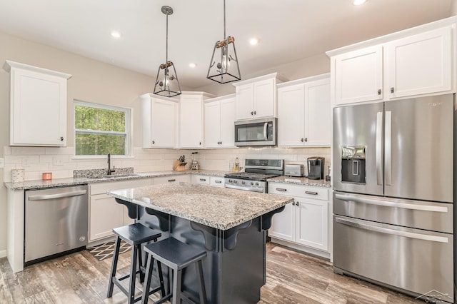 7302 Geraldine Cir, Swartz Creek, MI 48473 - kitchen with stainless steel appliances, a sink, white cabinets, backsplash, and recessed lighting