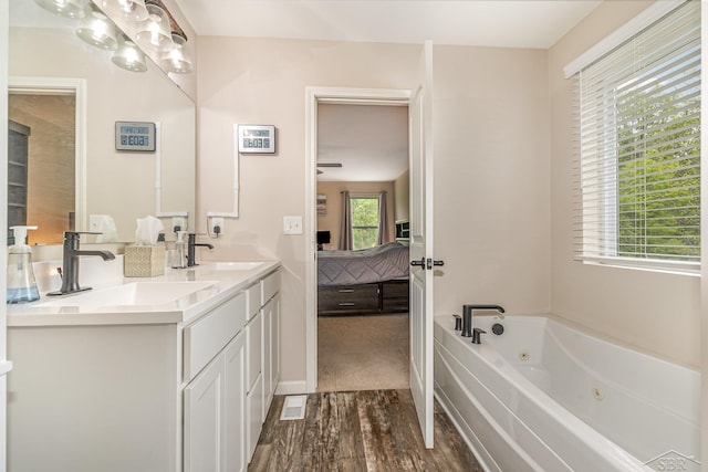 7302 Geraldine Cir, Swartz Creek, MI 48473 - ensuite bathroom with double vanity, wood finished floors, and a jetted tub