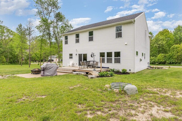 7302 Geraldine Cir, Swartz Creek, MI 48473 - back of property with an outdoor fire pit, a deck, and a yard