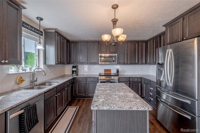 13109 River Rock Pass, Linden, MI 48451 - kitchen featuring appliances with stainless steel finishes, a sink, a center island, tasteful backsplash, and dark wood-style floors