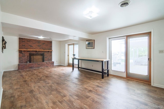 3266 Benstein Rd, Commerce Twp, MI 48382 - unfurnished living room featuring wood finished floors, baseboards, and a brick fireplace