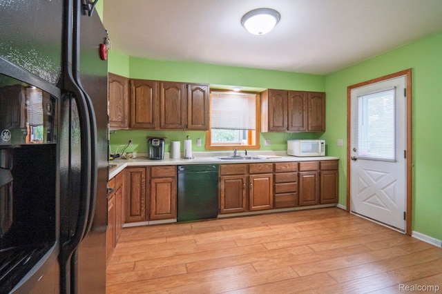 3266 Benstein Rd, Commerce Twp, MI 48382 - kitchen with black appliances, a sink, light wood-style floors, light countertops, and brown cabinets