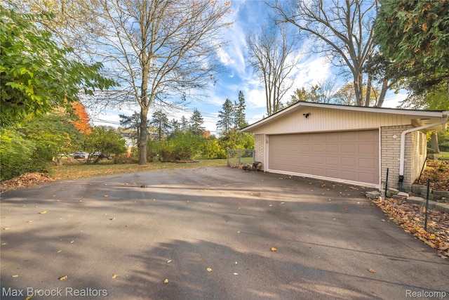 28290 Inkster Rd, Southfield, MI 48034 - view of side of property featuring a garage, brick siding, driveway, and an outbuilding