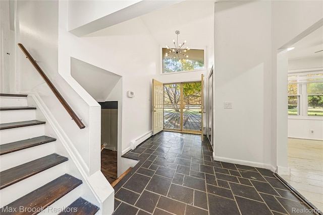 28290 Inkster Rd, Southfield, MI 48034 - foyer with a baseboard radiator, stone tile flooring, a towering ceiling, baseboards, and a chandelier