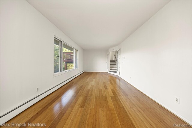 28290 Inkster Rd, Southfield, MI 48034 - unfurnished room with light wood-type flooring, a baseboard heating unit, stairs, and baseboards