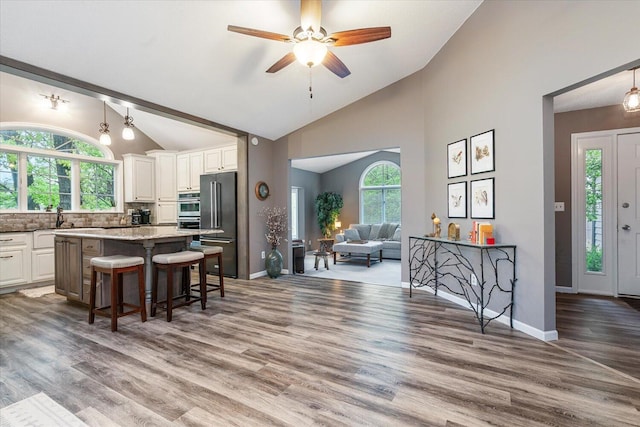5400 Laura Dr, Shelbyville, MI 49344 - kitchen with open floor plan, a kitchen breakfast bar, a center island, high quality fridge, and healthy amount of natural light