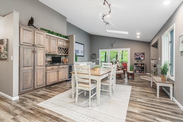 5400 Laura Dr, Shelbyville, MI 49344 - dining area featuring beverage cooler, vaulted ceiling, wood finished floors, baseboards, and a skylight