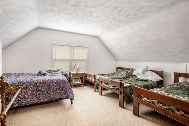 3050 Thorpe Dr, Delton, MI 49046 - carpeted bedroom with vaulted ceiling, wooden walls, and a textured ceiling