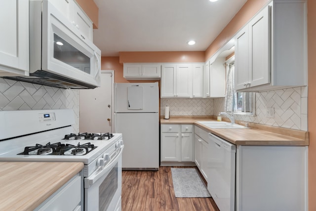 210 E Palmer Ave, Jackson, MI 49203 - kitchen featuring white appliances, a sink, white cabinetry, wood finished floors, and backsplash