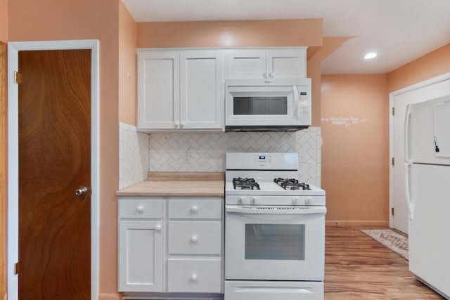 210 E Palmer Ave, Jackson, MI 49203 - kitchen with white appliances, white cabinets, tasteful backsplash, light countertops, and recessed lighting