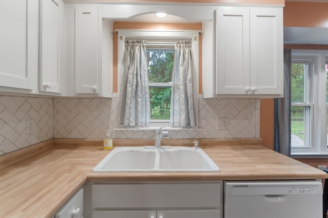210 E Palmer Ave, Jackson, MI 49203 - kitchen featuring white dishwasher, white cabinetry, a sink, and backsplash